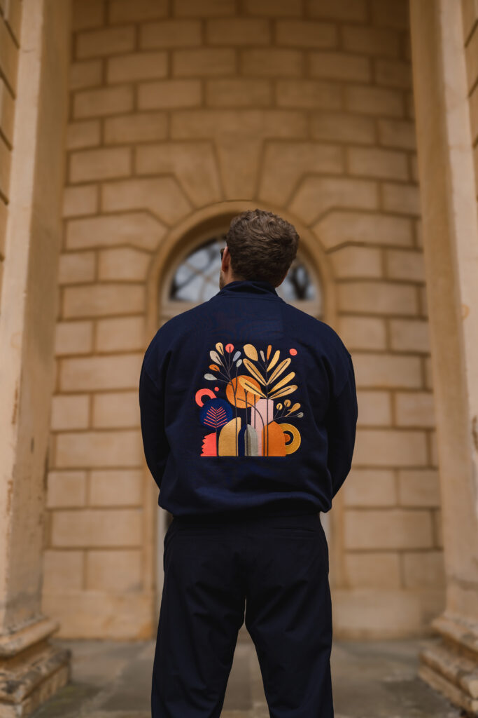 Dunkelblaues Kleidungsstück mit großem floralem und geometrischem Stickmotiv aus einer Kollektion von THE MEJD