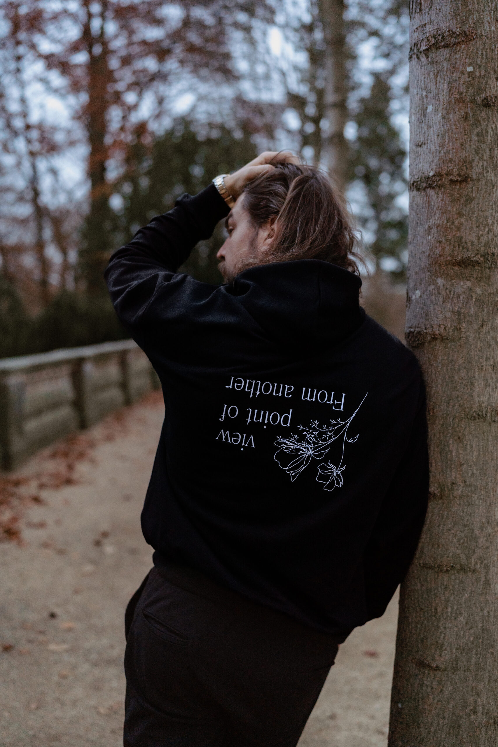 Schwarzer Hoodie mit weißer Linien- und Schriftstickerei auf dem Rücken